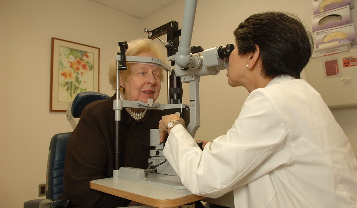 an elderly woman having her eyes examined by an ophthalmologist