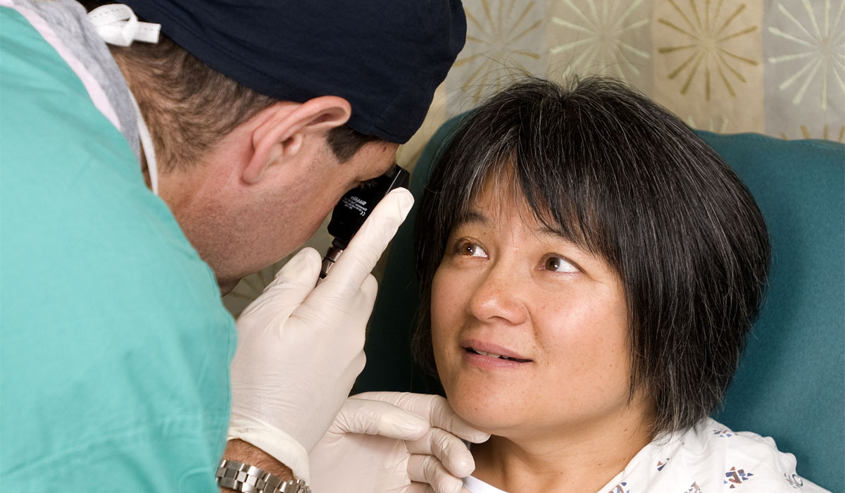 an-ophthalmologist-examines-a-woman's-eye-with-an-ophthalmoscope
