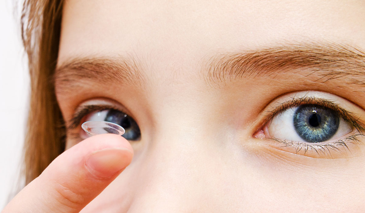 woman putting on a contact lense