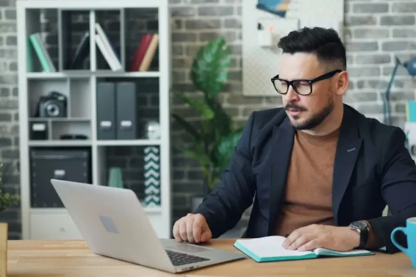 Man with glasses experiencing bloodshot eyes and digital eye strain from prolonged screen time.