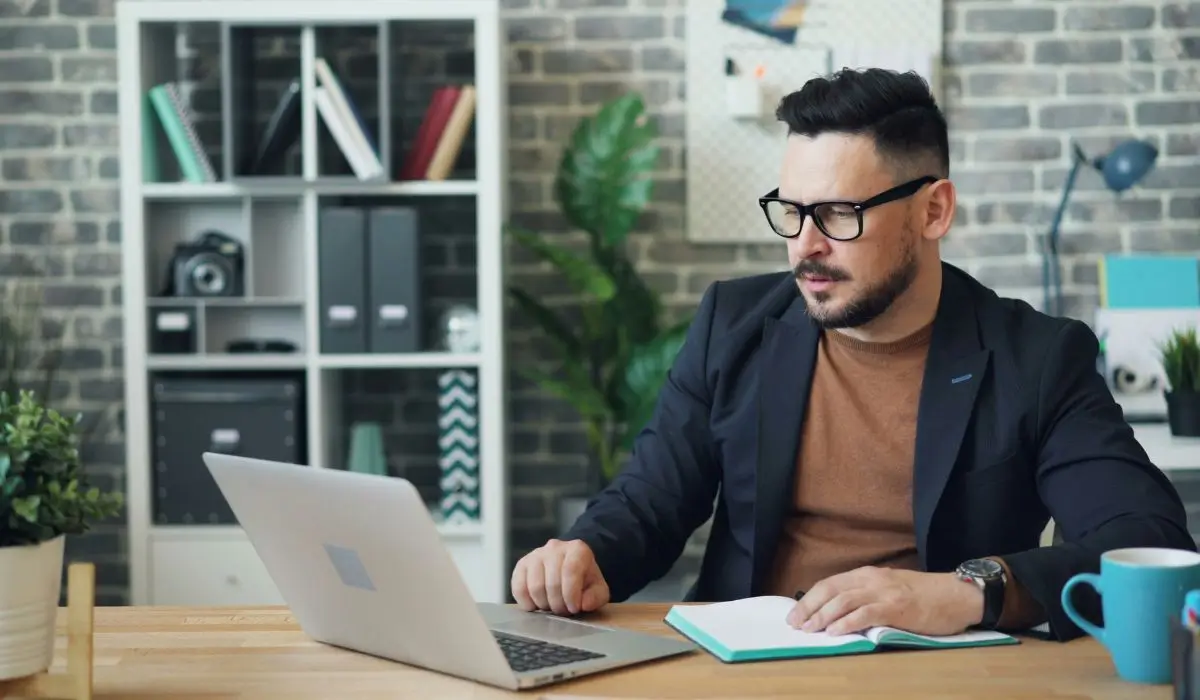 Man with glasses experiencing bloodshot eyes and digital eye strain from prolonged screen time.