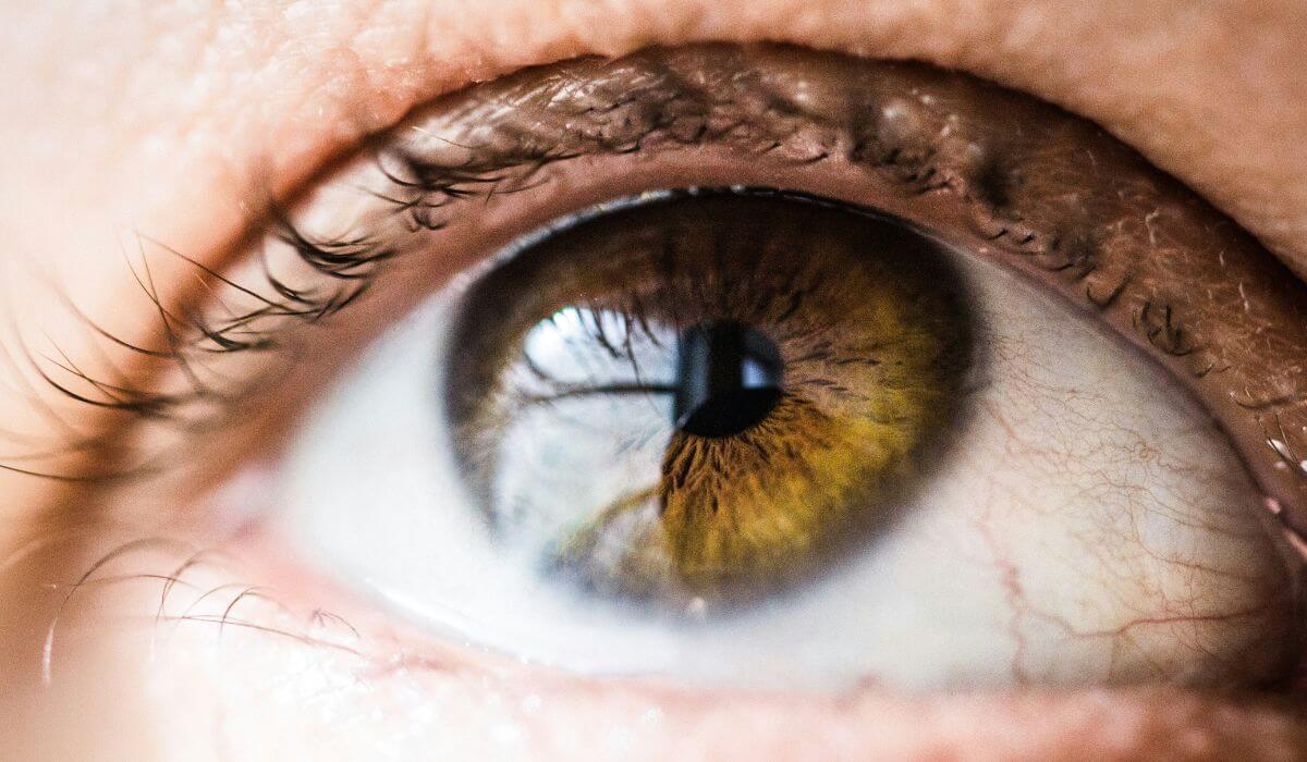 Detailed close-up of a human eye, highlighting the natural colors and textures, often affected by the condition of dry eyes.