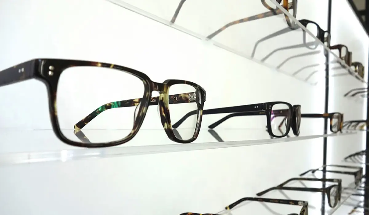 Stylish blue light eyeglasses are displayed on a shelf, designed to reduce digital screen strain and glare.