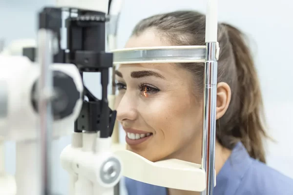 Female patient receiving professional Eye Exams at a modern clinic, ensuring eye health with advanced equipment.