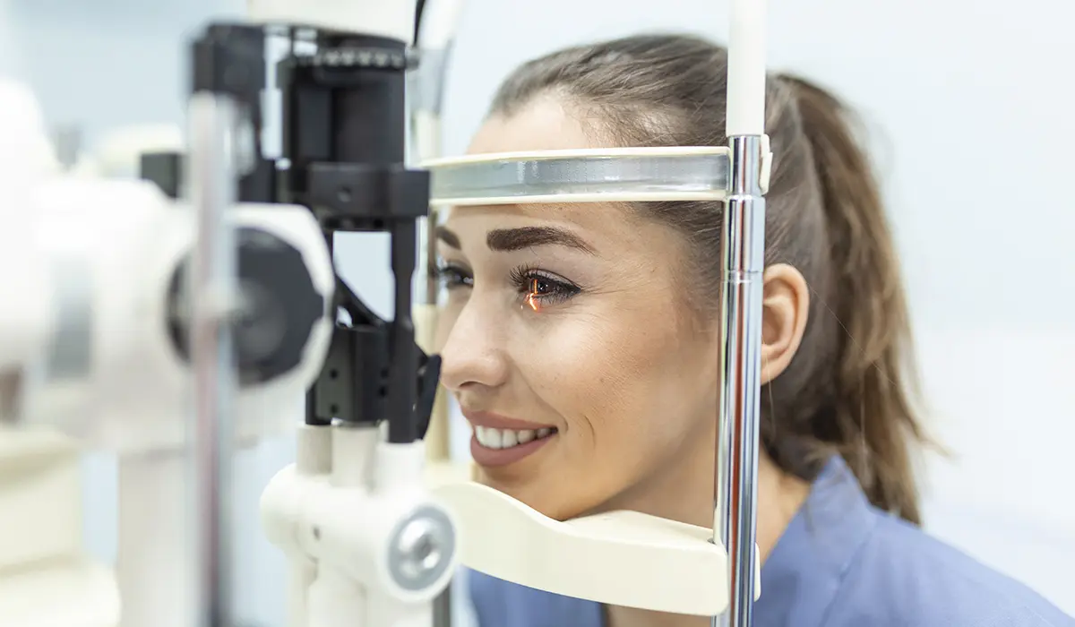 Female patient receiving professional Eye Exams at a modern clinic, ensuring eye health with advanced equipment.