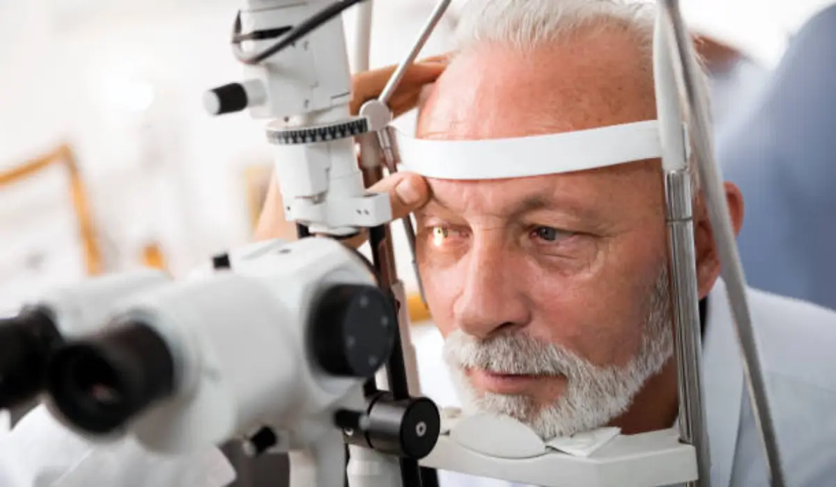 An elderly man gets an eye exam using specialized equipment to check for diabetes and eye health complications.