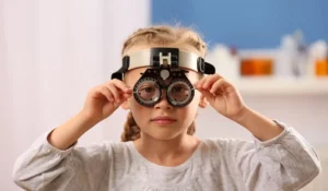 Young girl wearing trial frame for accurate pediatric Eye Exams in a professional optometry clinic setting.