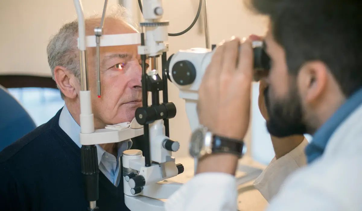 Older adult receiving detailed eye exam with retinal scanner to support vision after a concussion recovery and rehabilitation care.