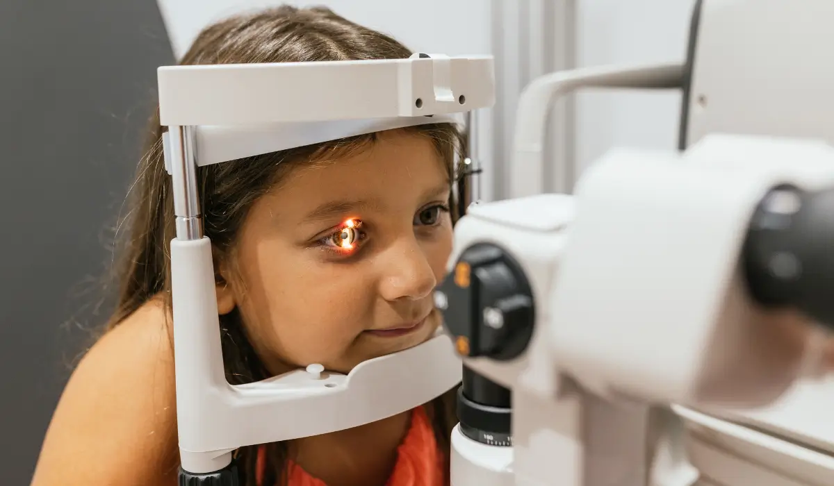 Young girl undergoing a pediatric eye exam to check for vision strain caused by too much screen time.