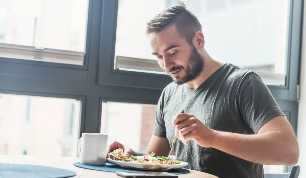 Man eating a healthy plate of foods that boost eye health naturally, promoting daily vision support.